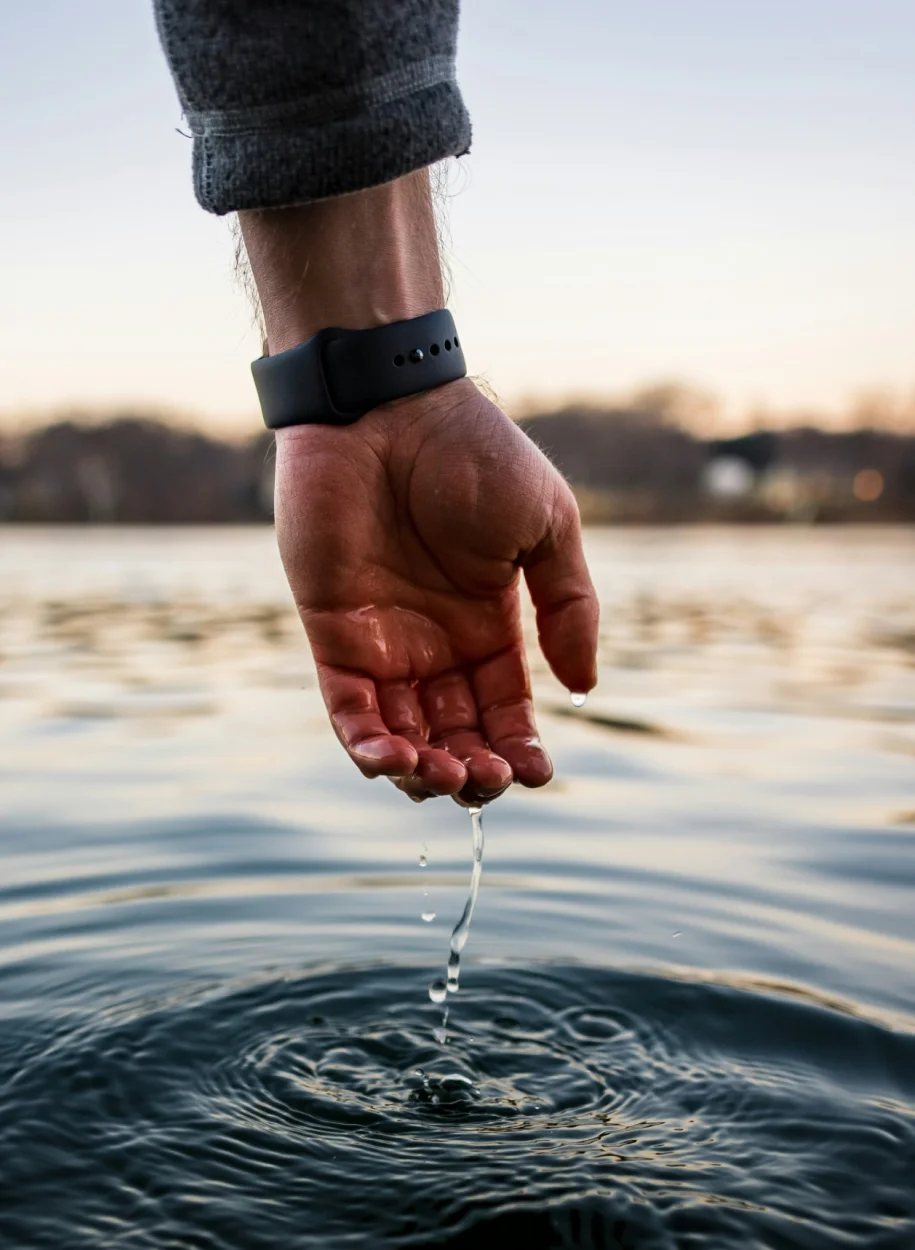 A man wearing boAt watch near a water marketing design