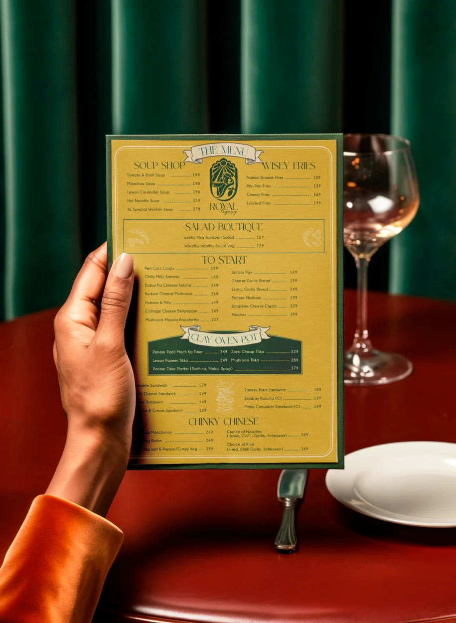 Stylish menu card from Royal Legacy, featuring a classic design, set against a luxurious dining ambiance with deep green and red hues