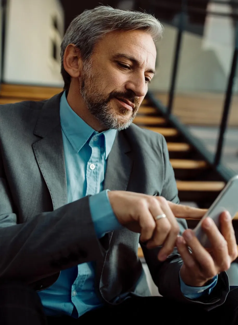 Man sitting on stairs using phone.